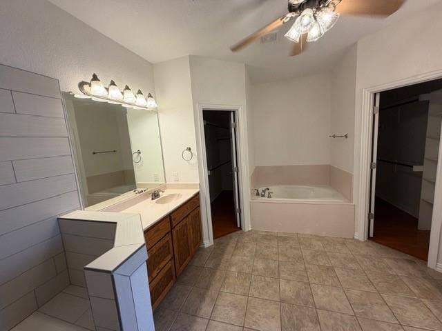 500 Leatherman Drive, Saginaw, TX 76179 Dual vanity with wood-finish cabinetry, built-in soaking tub, tile flooring, and ceiling fan