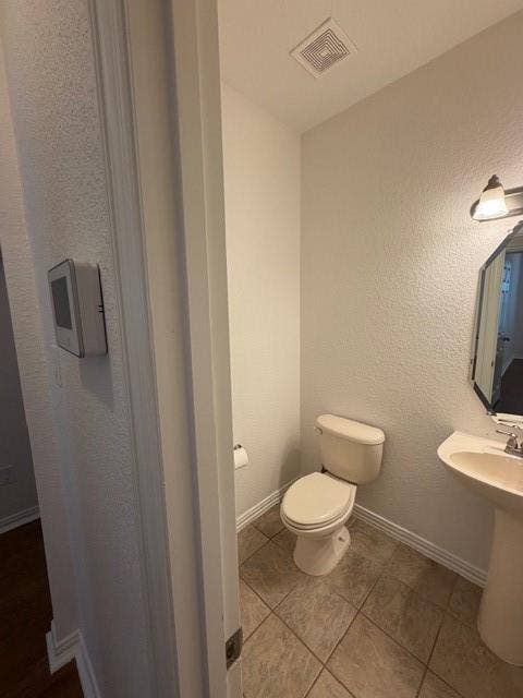 500 Leatherman Drive, Saginaw, TX 76179 Pedestal sink with polished chrome fixtures, wall-mounted light fixture, and tile flooring
