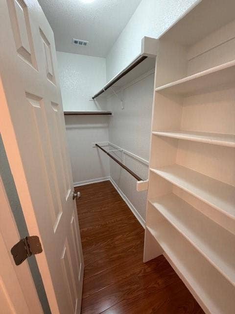 500 Leatherman Drive, Saginaw, TX 76179 White paneled door opening to a closet featuring wood-finish flooring, integrated shelving, and clothing rods