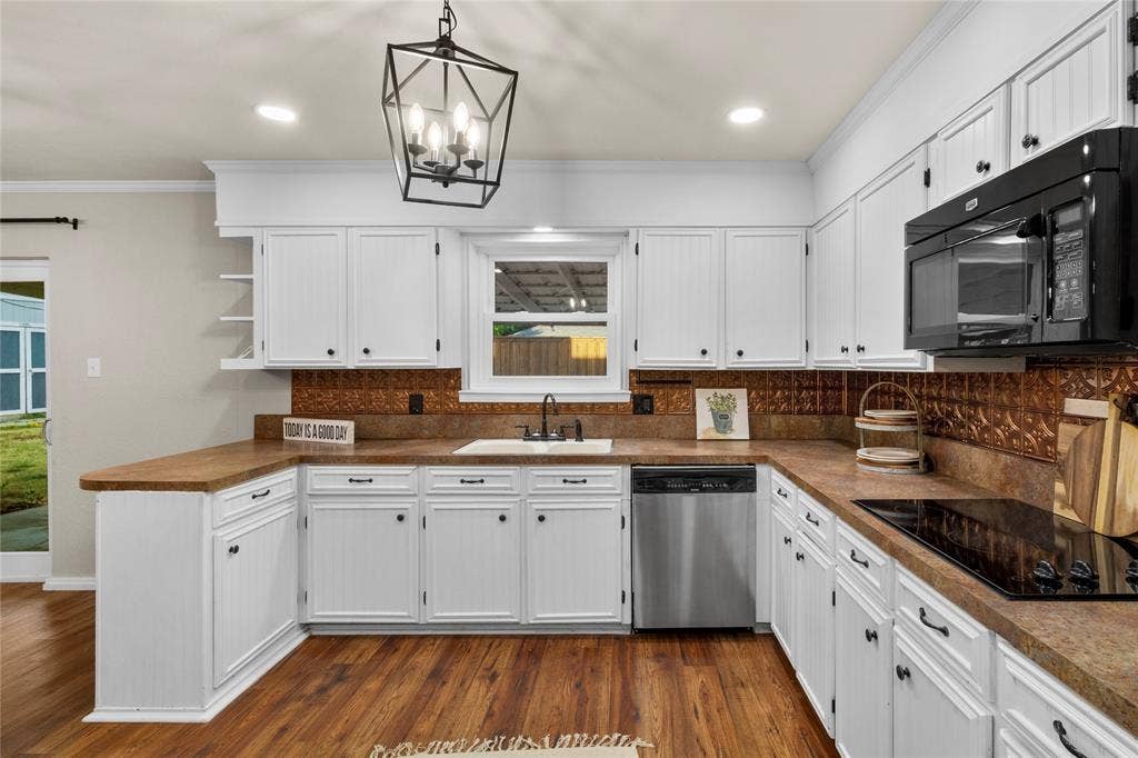 Kitchen featuring white cabinetry, wood-finish flooring, a built-in electric cooktop, a built-in microwave, and a stainless steel dishwasher