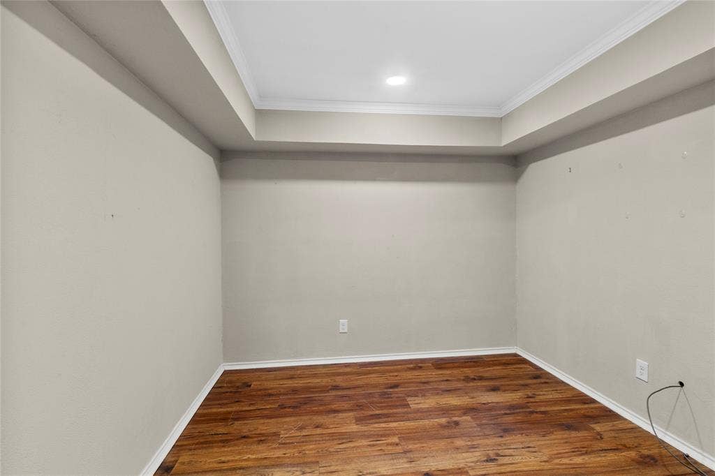Wood-finish flooring with crisp white baseboards, complemented by light-toned wall paint