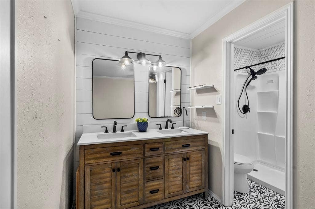 Dual vanity with white countertop, black hardware, and wood-finish cabinetry