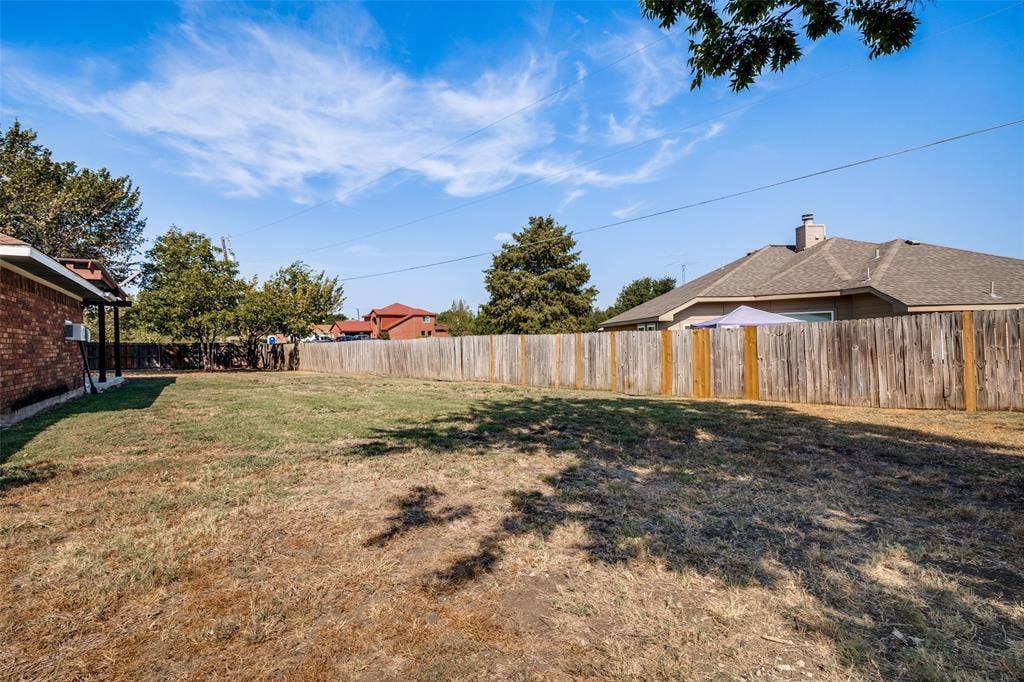6527 Leasa Court, Sachse, TX 75048 Spacious backyard area featuring a wooden privacy fence, and mature trees.