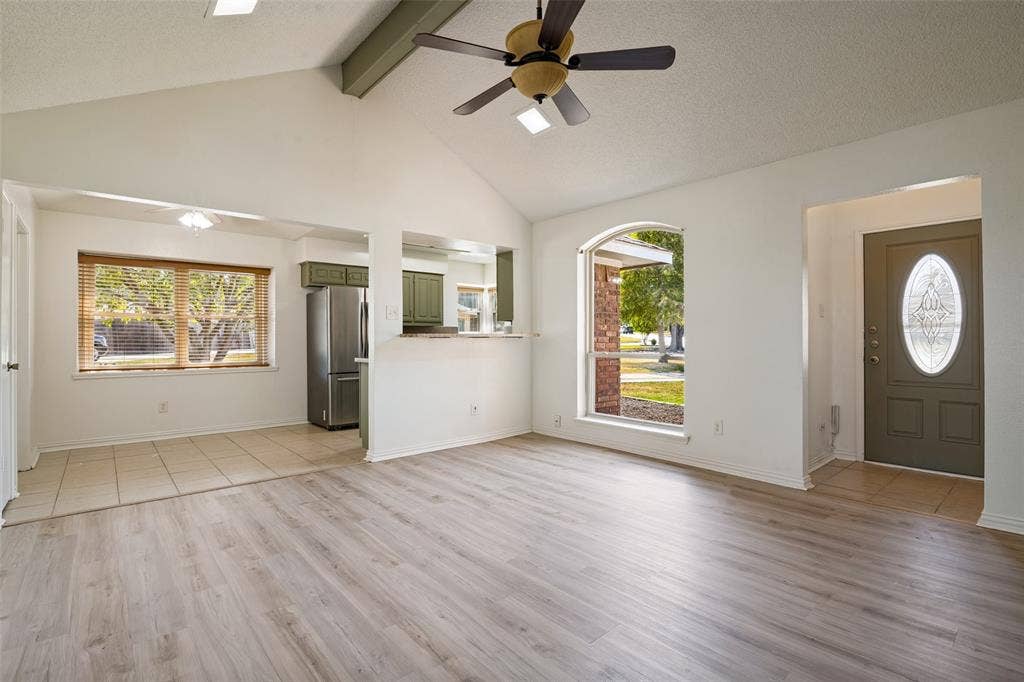 6527 Leasa Court, Sachse, TX 75048 Vaulted ceiling with exposed beam, wood-finish flooring, arched window.