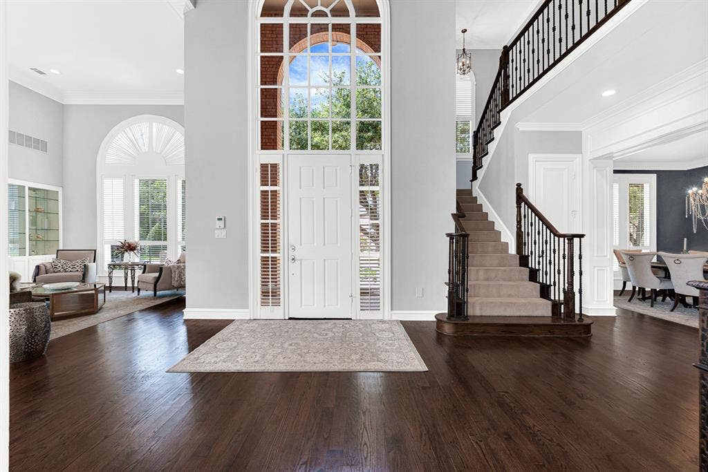 5325 BLAKE Drive, Plano, TX 75093 Rich hardwood floors and towering, double-height ceilings create a striking first impression as natural light floods the foyer through a dramatic arched window above the front door. It’s an inviting entrance that immediately sets an warm, sophisticated tone for greeting friends and family.
