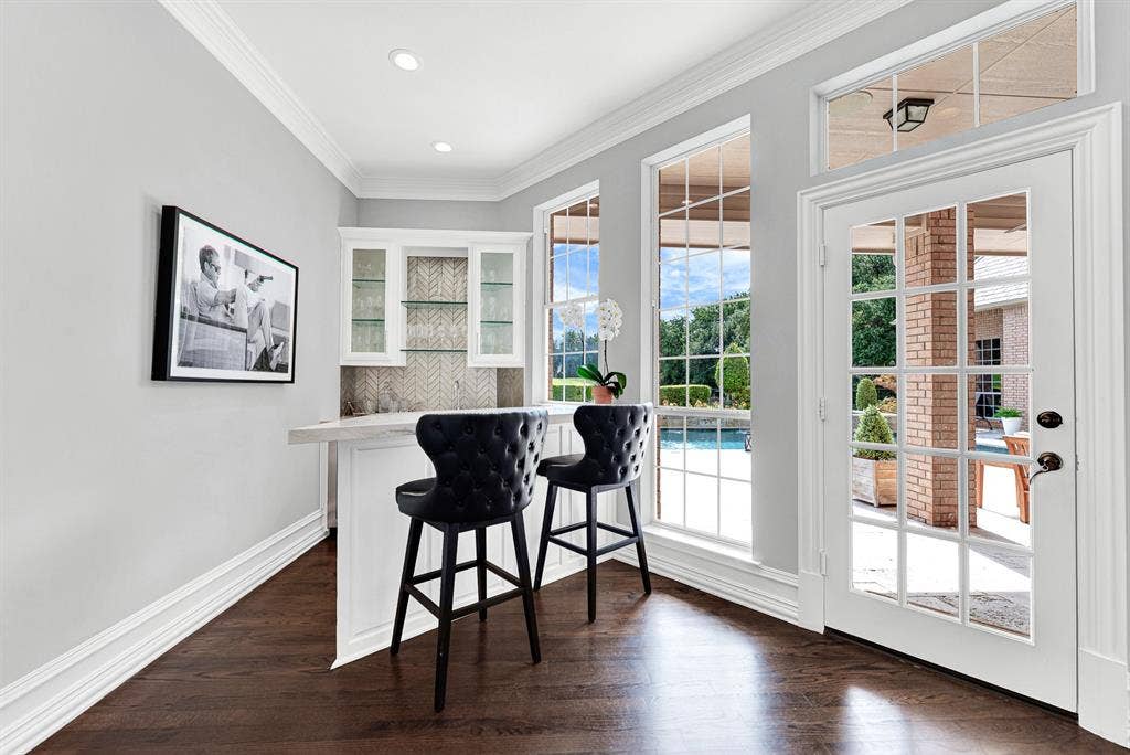 5325 BLAKE Drive, Plano, TX 75093 Tucked conveniently near the patio exit, this dedicated wet bar featuring counter seating serves as an ideal beverage station for indoor and outdoor gatherings. Large windows showcase pool views while French doors offer direct access to the covered entertaining deck