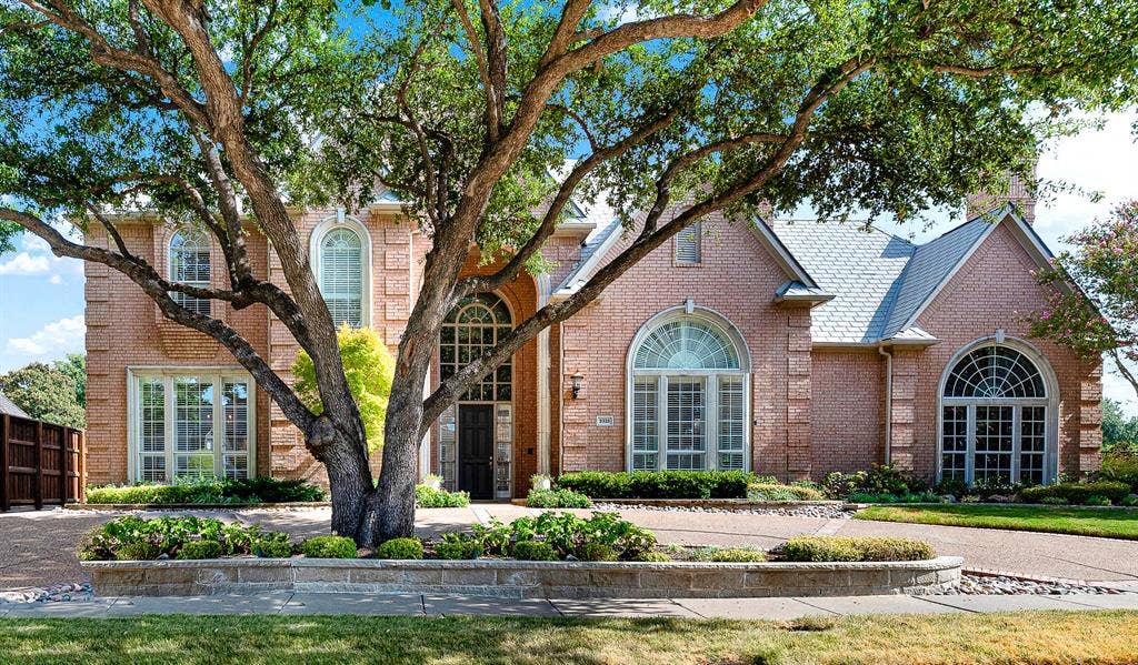 5325 BLAKE Drive, Plano, TX 75093 Framed by mature oak shade trees, this classic brick elevation features towering arched windows and a circular drive. You will love greeting neighbors from the sweeping front drive as soft afternoon light filters through the trees.