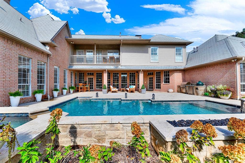 5325 BLAKE Drive, Plano, TX 75093 A spacious covered patio and expansive pool deck seamlessly bridge indoor-outdoor living, anchored by a stone fire pit. Host unforgettable summer barbecues while kids swim and guests gather comfortably by the fire pit.