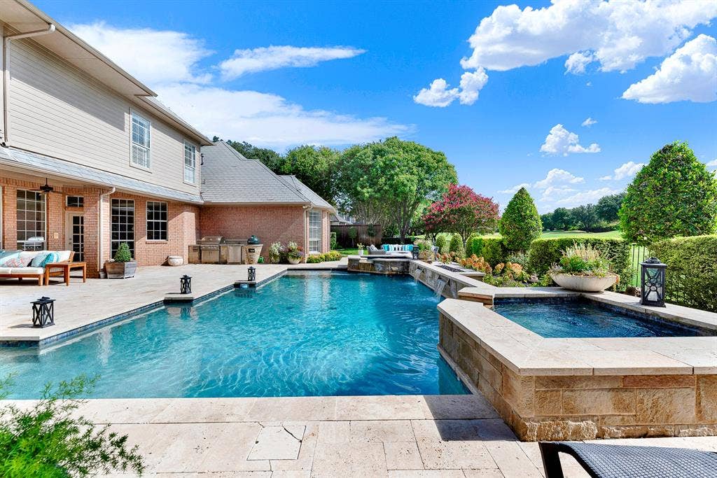 5325 BLAKE Drive, Plano, TX 75093 Sparkling blue waters take center stage alongside a stone-encased spa, custom water features, and manicured landscaping. Imagine spending sunny weekends splashing with family or relaxing in the warm spa under open blue skies.