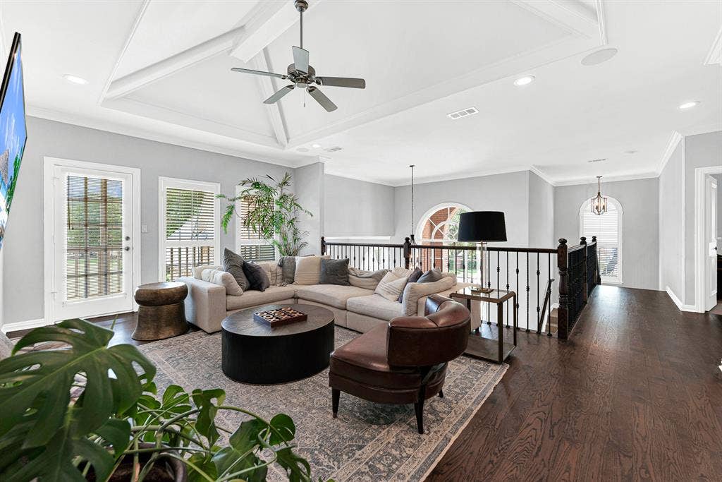 5325 BLAKE Drive, Plano, TX 75093 A plush sectional and leather armchair anchor this open upstairs entertainment space overlooking the main staircase landing. Large windows frame elevated backyard views, while French door access leads seamlessly out to the covered balcony.