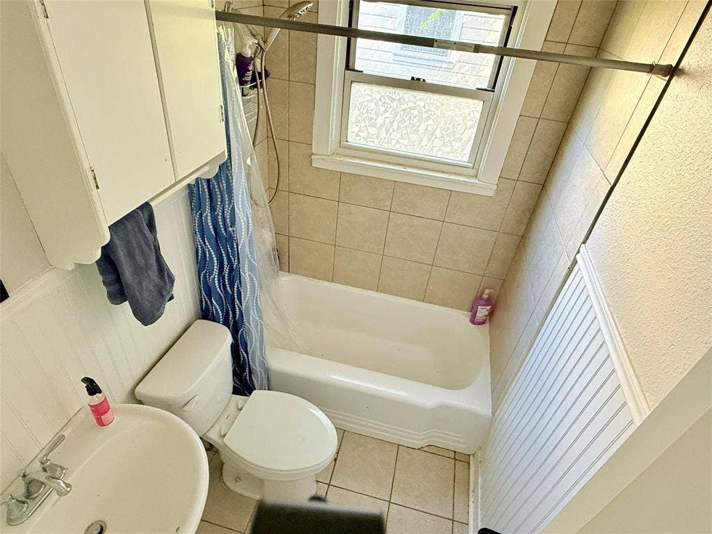 3014 Crestview Street, Tyler, TX 75701 Built-in white cabinetry, shower/tub combination, tiled walls, and beadboard paneling