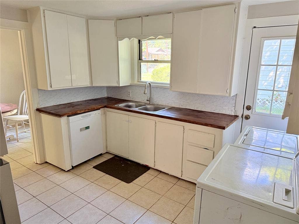 3014 Crestview Street, Tyler, TX 75701 White cabinetry, wood-finish countertops, tile backsplash, built-in dishwasher, and tile flooring
