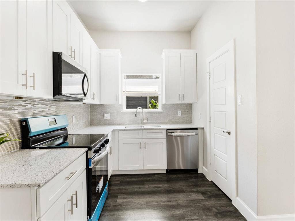292 Harris Boulevard, Malakoff, TX 75148 Kitchen featuring white shaker cabinetry, speckled countertops, stainless steel appliances, a tile backsplash, and wood-finish flooring