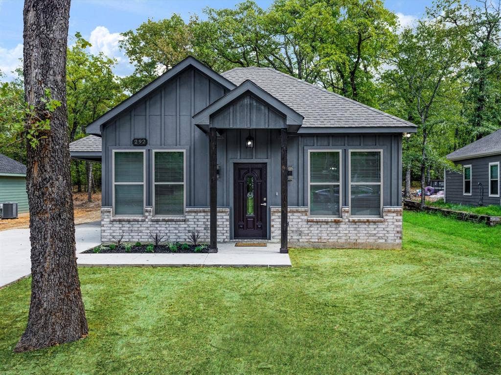 292 Harris Boulevard, Malakoff, TX 75148 Board and batten siding, stone veneer accents, covered entry, front yard, and concrete walkway
