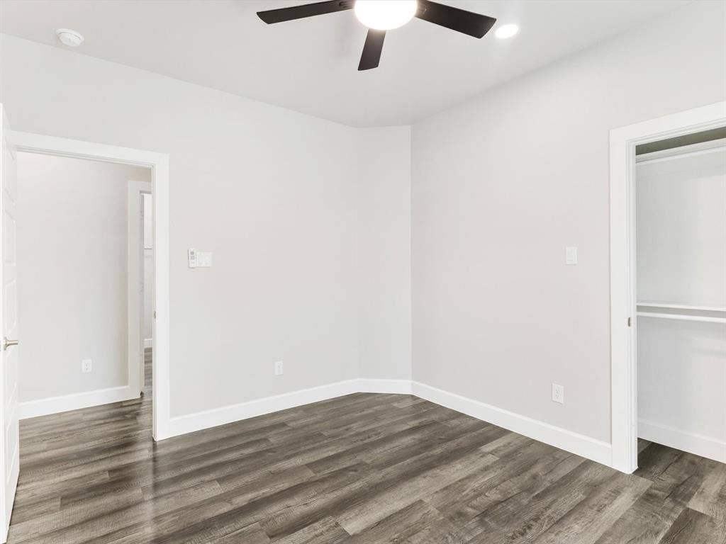 292 Harris Boulevard, Malakoff, TX 75148 Room featuring wood-finish flooring, white walls, a ceiling fan with integrated lighting, and a closet with shelving