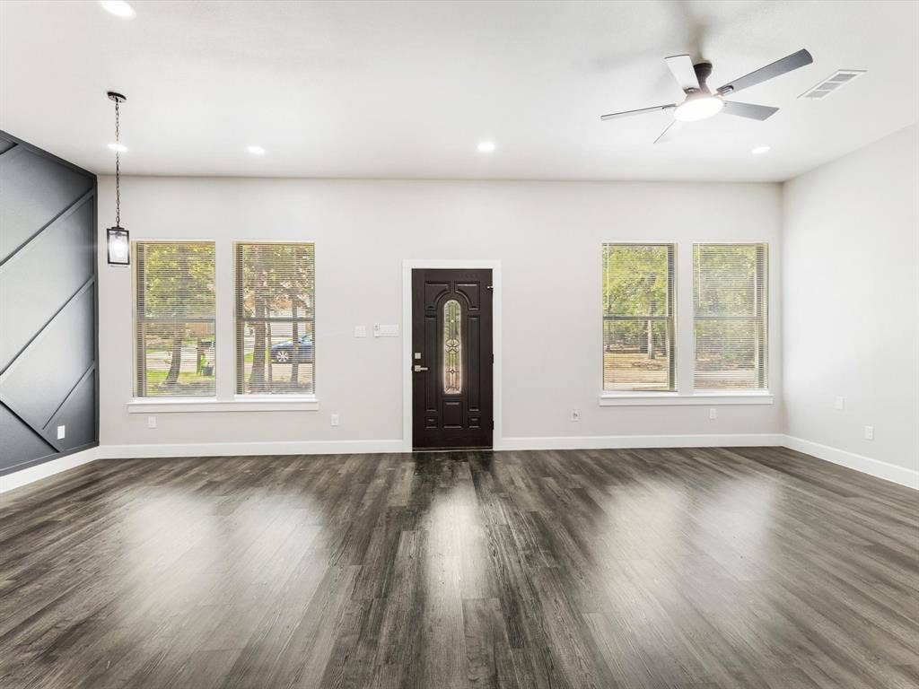 292 Harris Boulevard, Malakoff, TX 75148 Wood-finish flooring throughout, modern ceiling fan, recessed lighting, decorative accent wall, and a detailed front entry door