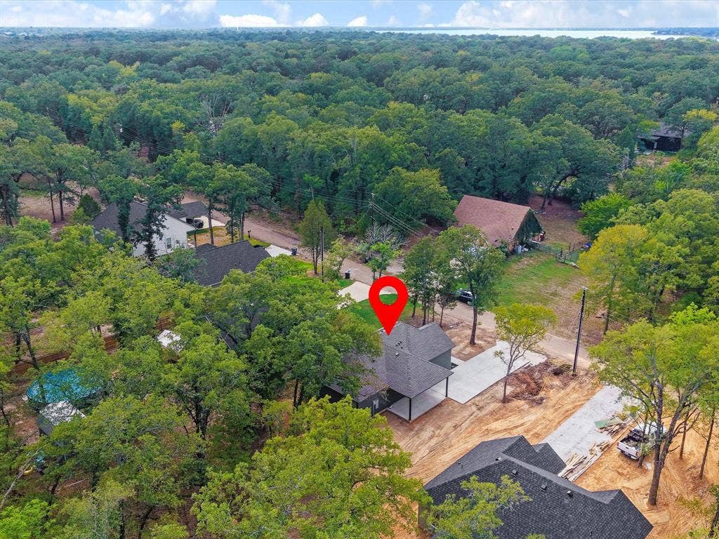 292 Harris Boulevard, Malakoff, TX 75148 Expansive treed lot featuring a newly constructed residence with a dark shingled roof, a concrete driveway, and surrounding mature trees
