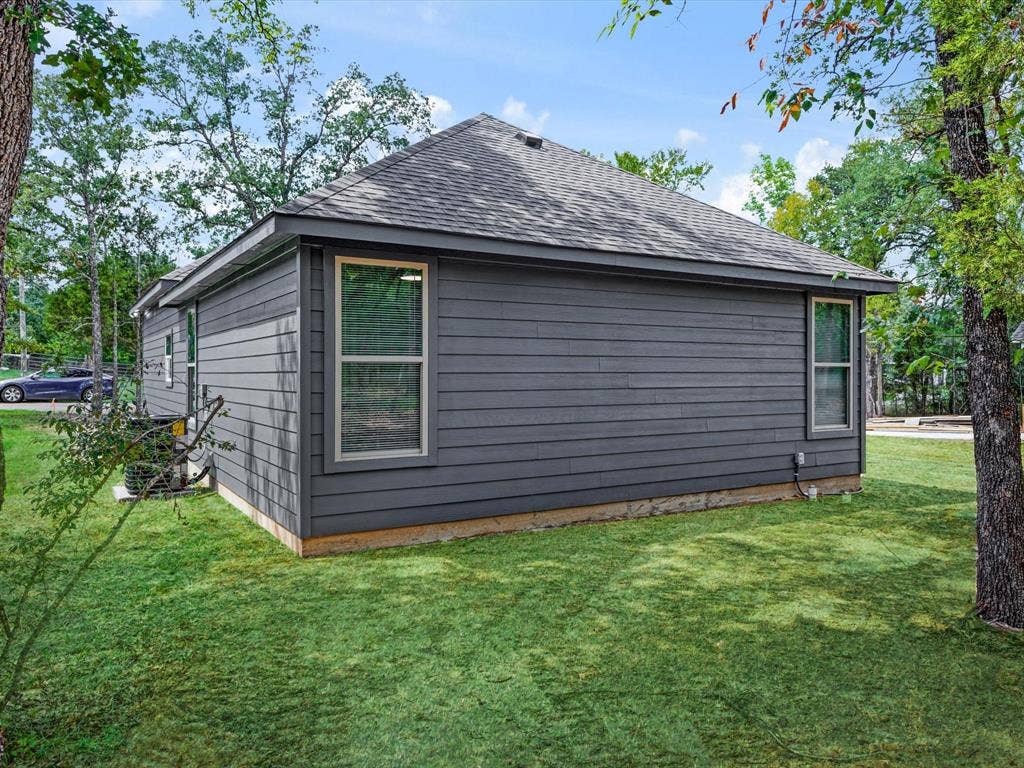 292 Harris Boulevard, Malakoff, TX 75148 Exterior with gray horizontal siding, a dark shingle roof, and multiple windows with light-colored frames