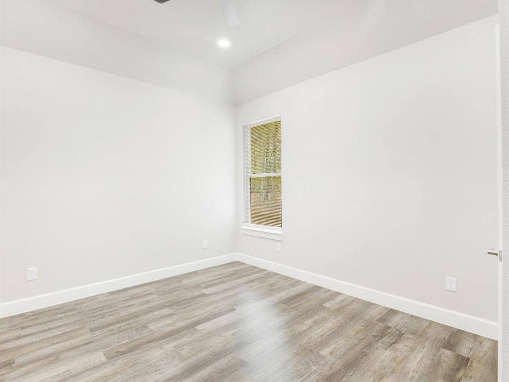 292 Harris Boulevard, Malakoff, TX 75148 Vaulted ceiling with a recessed light fixture, a single window, and wood-finish flooring
