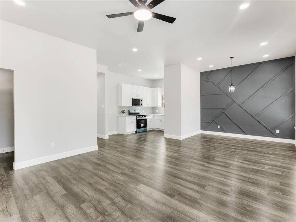 292 Harris Boulevard, Malakoff, TX 75148 Open-concept living space with wood-finish flooring, recessed lighting, ceiling fan, and a decorative accent wall