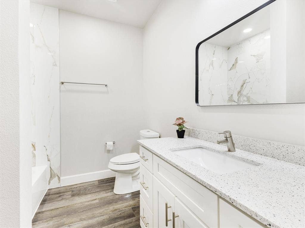 292 Harris Boulevard, Malakoff, TX 75148 White vanity with brushed nickel hardware, integrated sink, and speckled countertop