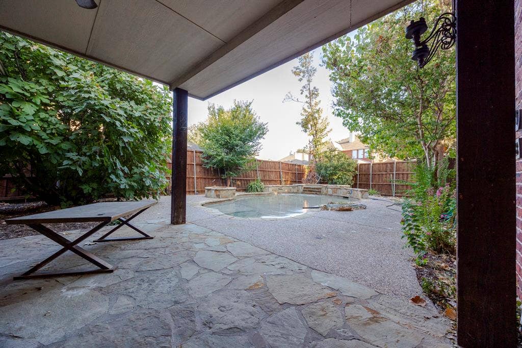 6405 Sapphire Drive, McKinney, TX 75070 Covered patio area with flagstone paving, a swimming pool, and mature perimeter landscaping