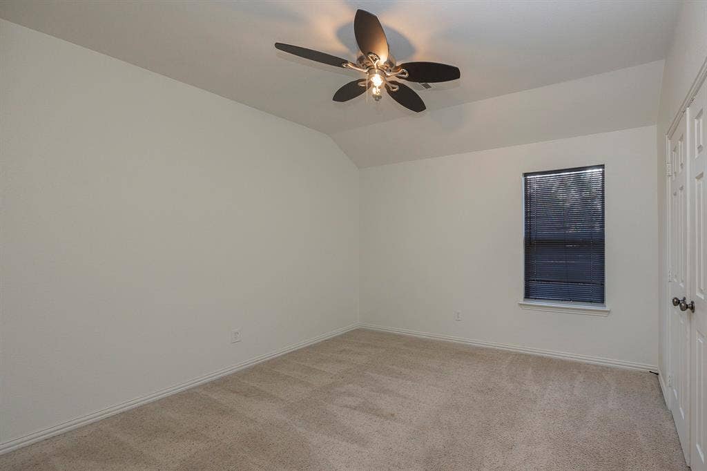 6405 Sapphire Drive, McKinney, TX 75070 Neutral-toned carpet flooring, a window with horizontal blinds, a ceiling fan with integrated lighting, and a closet with bifold doors