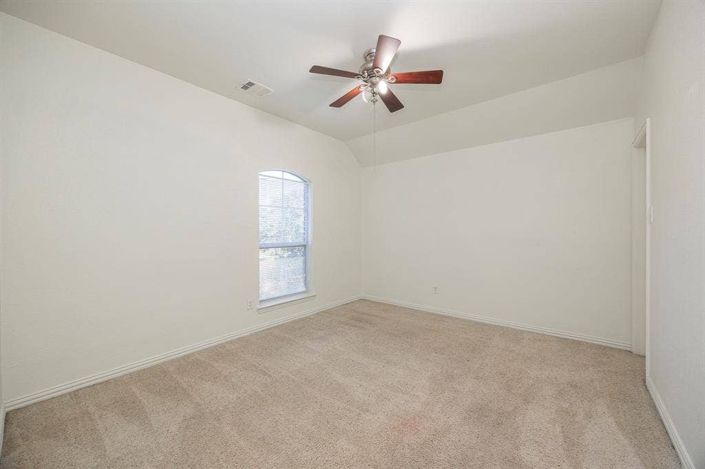 6405 Sapphire Drive, McKinney, TX 75070 Arched window, ceiling fan with light kit, neutral carpeting, and vaulted ceiling