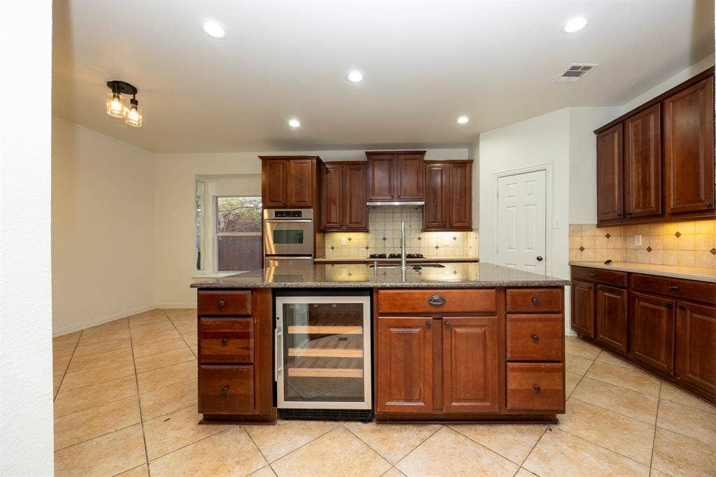 6405 Sapphire Drive, McKinney, TX 75070 Kitchen featuring a central island, recessed lighting, tile flooring, wood cabinetry, and a built-in wine refrigerator