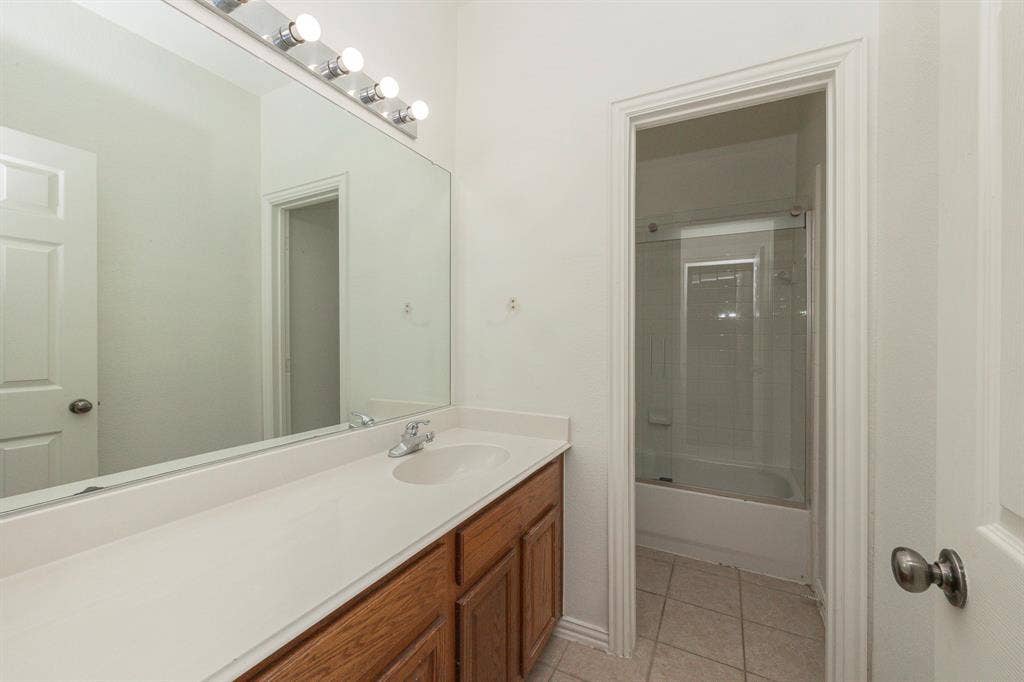 6405 Sapphire Drive, McKinney, TX 75070 Integrated vanity with wood-finish cabinetry, single basin, and light-toned countertop