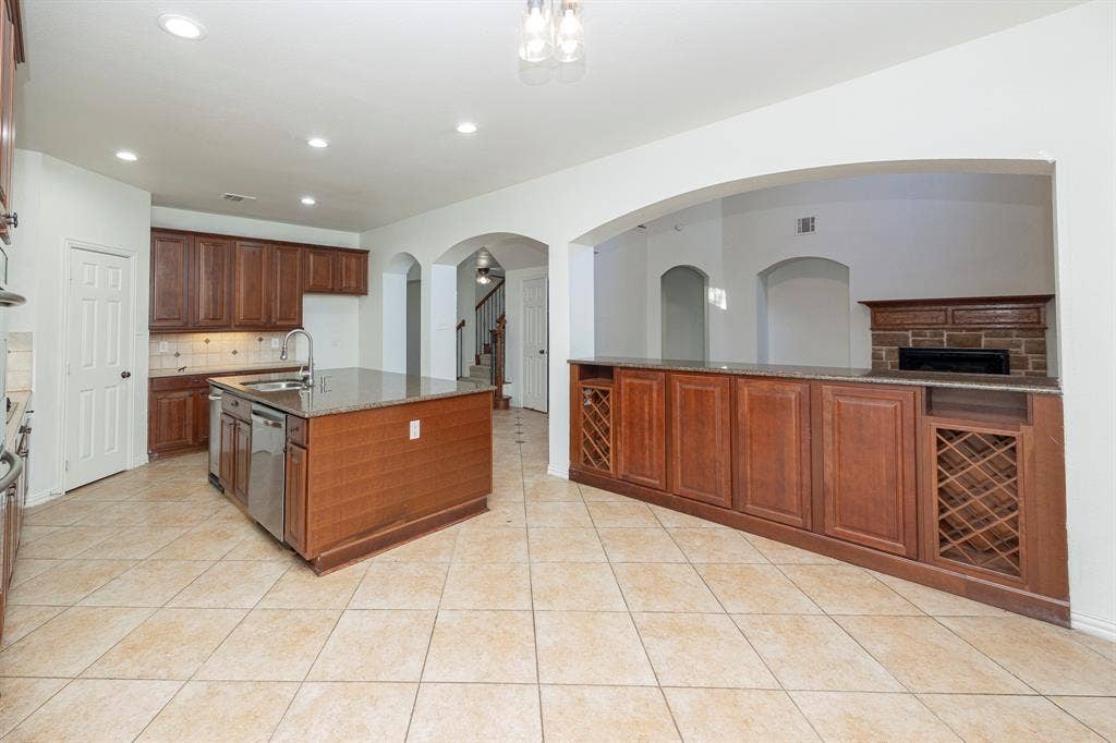 6405 Sapphire Drive, McKinney, TX 75070 Spacious kitchen featuring a central island with integrated sink, stainless steel dishwasher, and ample counter space