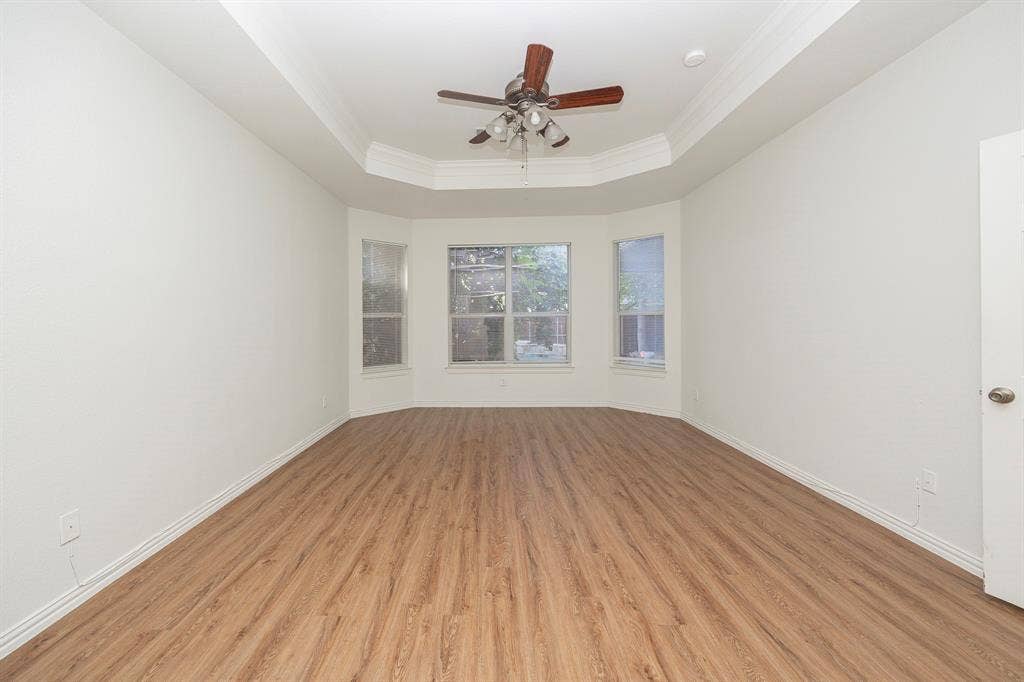 6405 Sapphire Drive, McKinney, TX 75070 Tray ceiling, wood-finish flooring, bay windows, and a ceiling fan
