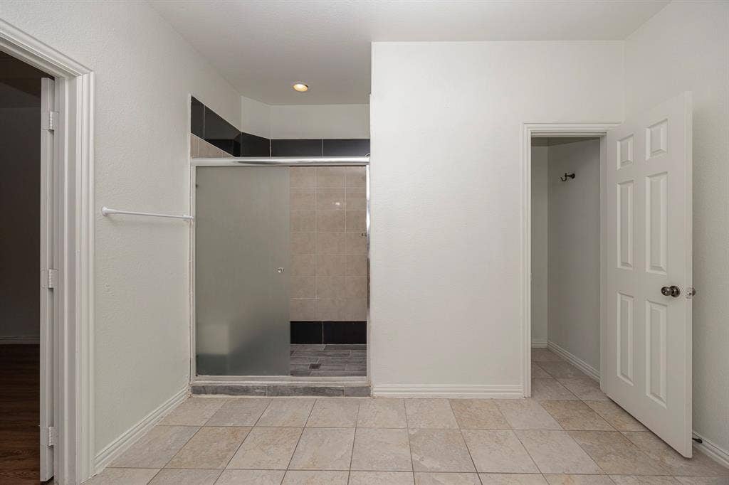 6405 Sapphire Drive, McKinney, TX 75070 Tiled flooring, walk-in shower with frosted glass enclosure, recessed lighting, and panel doors
