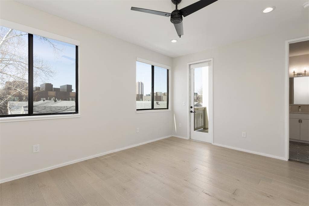 Unfurnished bedroom featuring light wood finished floors, recessed lighting, connected bathroom, ceiling fan, and access to outside