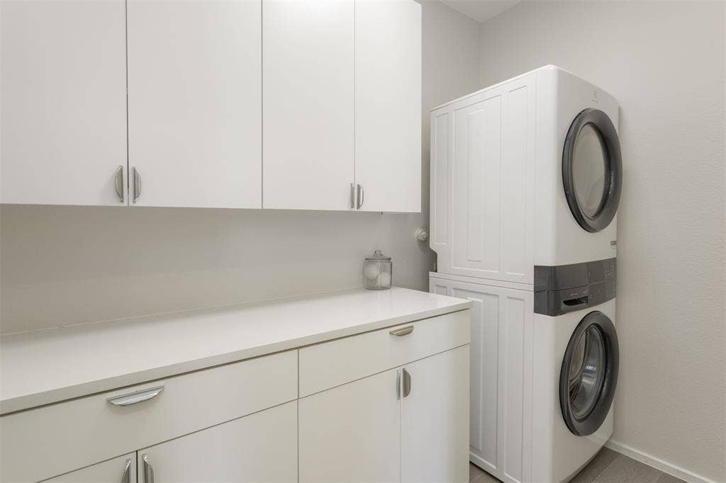 Laundry area with stacked washer / drying machine and cabinet space