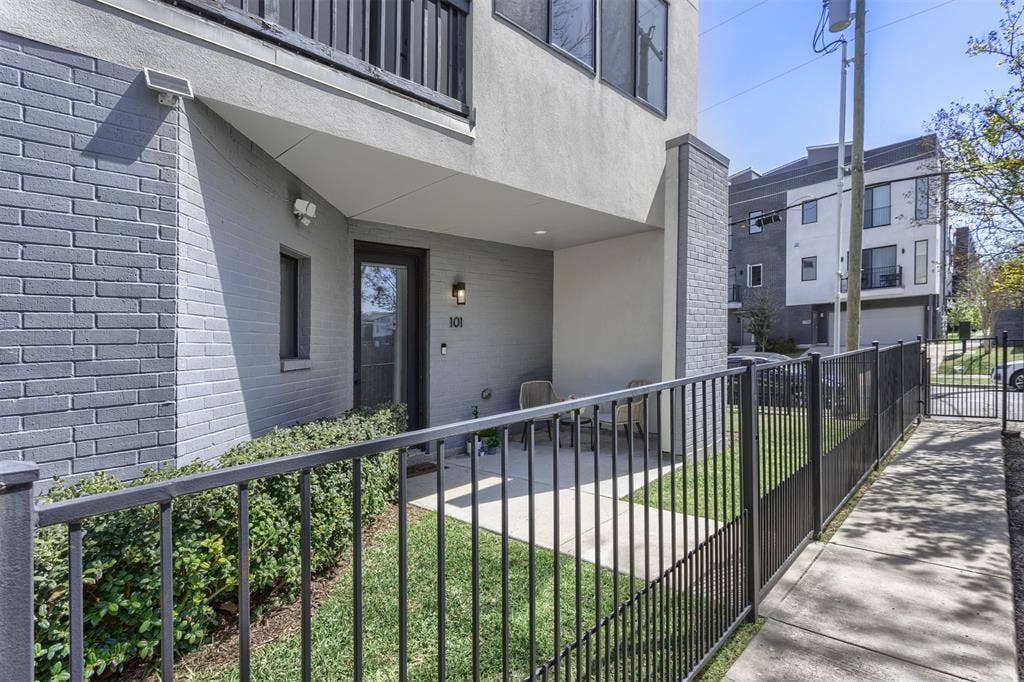 Entrance to property with a patio area, brick siding, and stucco siding