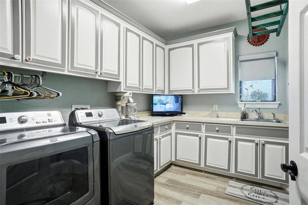 Laundry room with sink and drip area and plenty of storage and counter space.