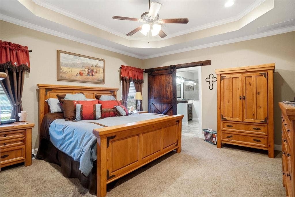 Primary with barn door that leads to the bathroom with a huge walk-in closet with built in shelving.
