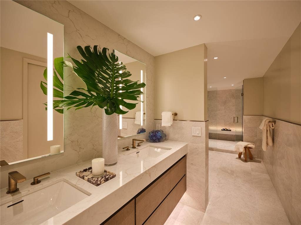 3310 Fairmount Street, #P3B, Dallas, TX 75201 Primary bath with Iceberg honed-marble floors and wainscoting. Large shower has a floating bench with built-in LED lighting. Adjoining custom walk-in closet.