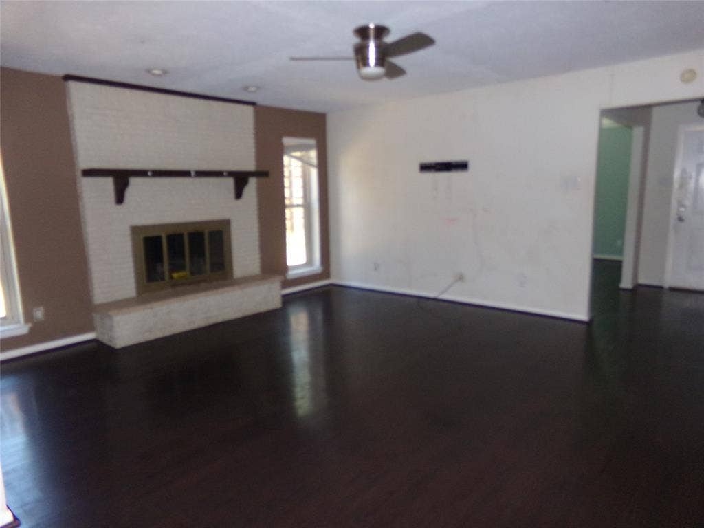 211 S Alexander Avenue, Duncanville, TX 75116 Dark wood-finish flooring, white brick fireplace with hearth, recessed lighting, and ceiling fan