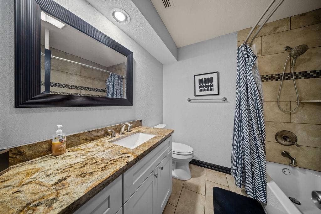 9302 Chimney Sweep Lane, Dallas, TX 75243 Vanity with stone countertop, undermount sink, and brushed nickel faucet