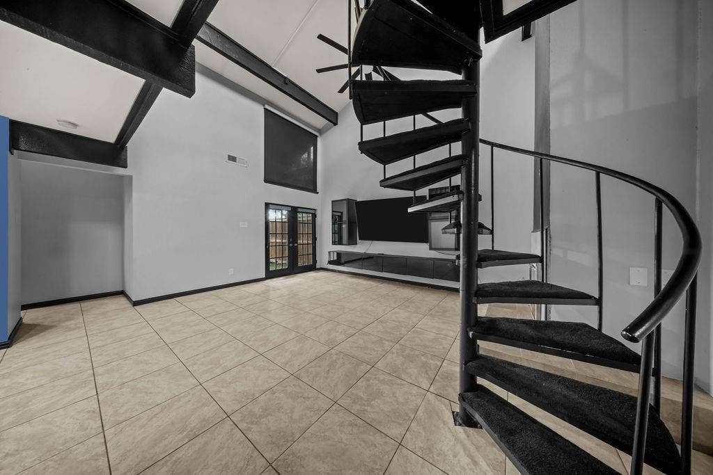 9302 Chimney Sweep Lane, Dallas, TX 75243 Vaulted ceilings with exposed beams, spiral staircase with carpeted treads, light-toned tile flooring, and double glass-paneled doors
