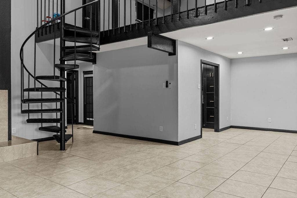 9302 Chimney Sweep Lane, Dallas, TX 75243 Black spiral staircase, recessed lighting, tile flooring, and dark trim