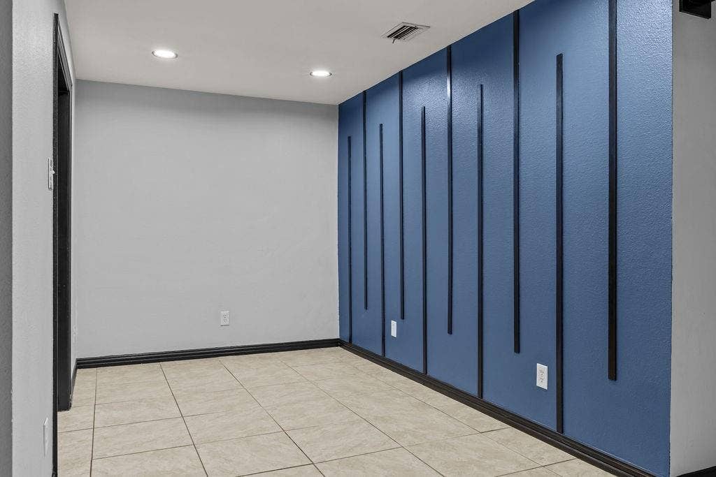 9302 Chimney Sweep Lane, Dallas, TX 75243 Recessed ceiling lighting, blue accent wall with vertical paneling, light-colored tile flooring, and dark trim
