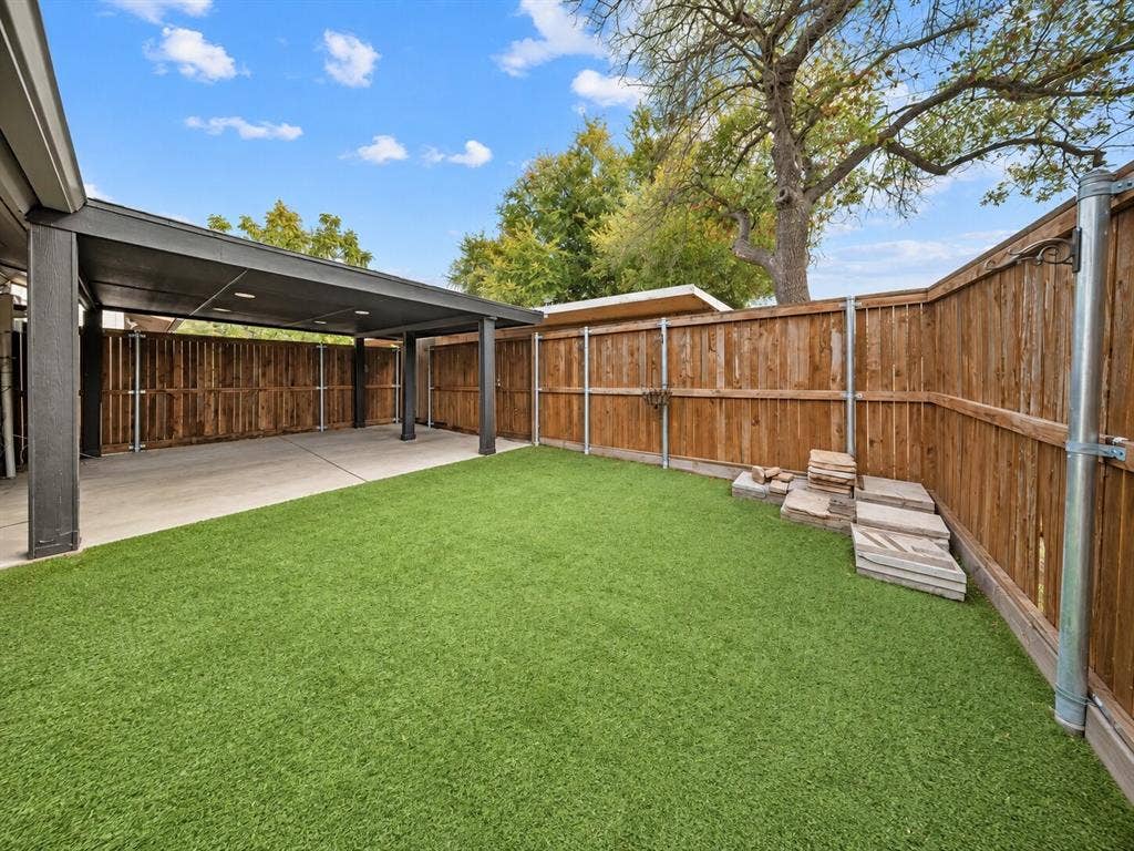9302 Chimney Sweep Lane, Dallas, TX 75243 Black cabinetry paired with granite countertops, stainless steel appliances, a tiled backsplash, and light-toned floor tiles