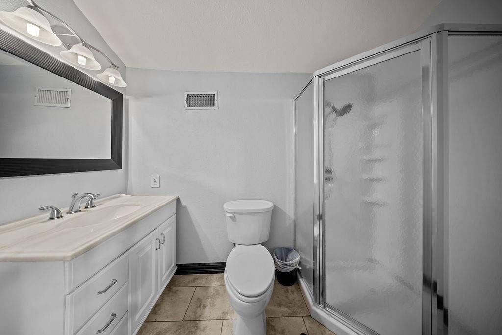 9302 Chimney Sweep Lane, Dallas, TX 75243 White vanity with integrated sink, chrome faucet, framed mirror, and tiled flooring