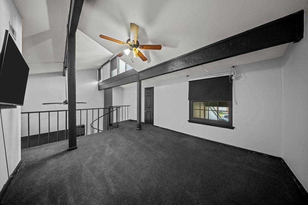 9302 Chimney Sweep Lane, Dallas, TX 75243 Vaulted ceiling featuring exposed beams, dark carpeting, and a ceiling fan