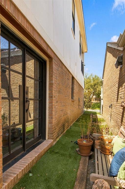46 Crown Place, Richardson, TX 75080 Brick and siding exterior featuring a glass-paneled entry door, a brick threshold, and artificial turf landscaping