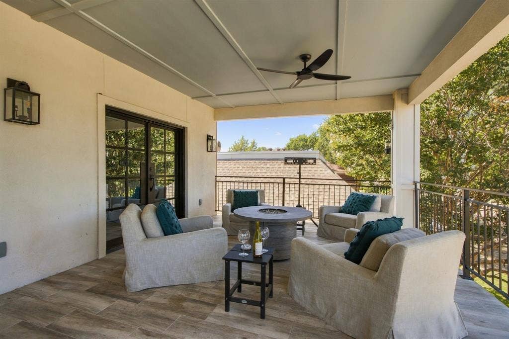 46 Crown Place, Richardson, TX 75080 Covered balcony featuring wood-finish flooring, a ceiling fan, and black metal railings