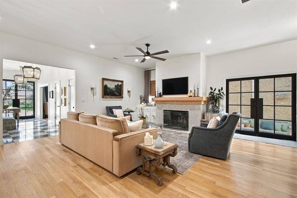 46 Crown Place, Richardson, TX 75080 Hardwood flooring, fireplace with stone surround and wood mantel, recessed lighting, ceiling fan, and French doors